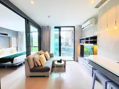 a living room with a couch and a bed at Modern Urban Living Kamala in Kamala Beach