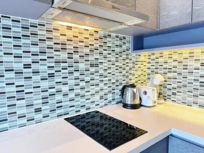 a kitchen with blue and yellow tiles on the wall at Modern Urban Living Kamala in Kamala Beach