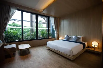 a bedroom with a large bed and a large window at The Arch Phuket Hotel in Ban Ket Ho