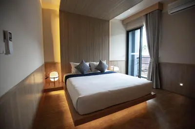 a bedroom with a bed and a large window at The Arch Phuket Hotel in Ban Ket Ho