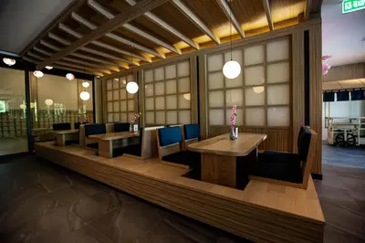 a restaurant with two tables and chairs and windows at The Arch Phuket Hotel in Ban Ket Ho
