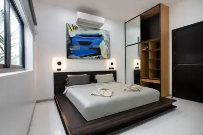 a bedroom with a large white bed and a tv at Villa Brianna Luxuria 2 - Rawai in Phuket Town