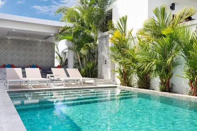 a swimming pool with white lounge chairs and a villa at Villa Brianna Luxuria 2 - Rawai in Phuket Town