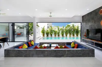 a living room with a large couch with colorful pillows at Villa Brianna Luxuria 2 - Rawai in Phuket Town
