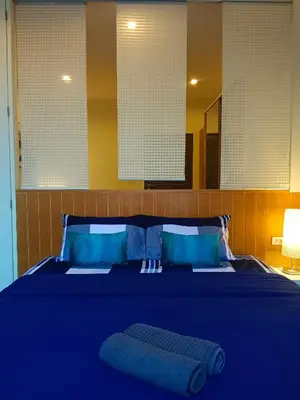 a bedroom with a blue bed with blue pillows at Hill Myna Condotel by Bcare - One Bedroom in Ban Thalat Choeng Thale