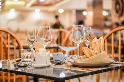 a table with wine glasses and napkins on it at The Marin Phuket Kamala Beach in Kamala Beach