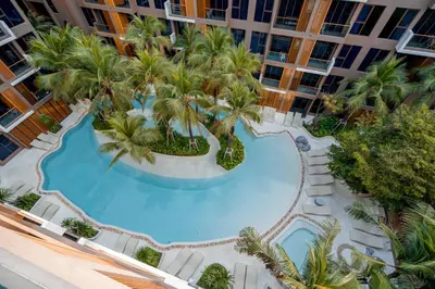 an overhead view of a swimming pool in a building with palm trees at The Marin Phuket Kamala Beach in Kamala Beach