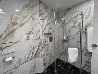 a bathroom with a shower with a marble wall at Bliss Patong - 2Br Sea View Condo - Roof Top Pool in Patong Beach