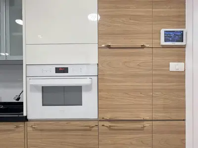 a kitchen with a white oven and wooden cabinets at Bliss Patong - 2Br Sea View Condo - Roof Top Pool in Patong Beach