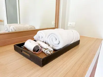 a suitcase with towels on the floor in front of a mirror at Favorite Place in Kata Beach