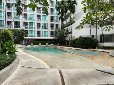 a swimming pool in front of a large building at 5 Floor - The Base Downtown Condominium next to Central Shopping Mall in Phuket Town