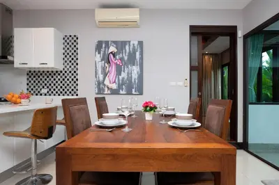 a wooden table and chairs in a kitchen at Private Pool Villa Nai Harn Beach in Rawai Beach