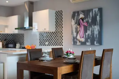 a wooden table with chairs and a dining room at Private Pool Villa Nai Harn Beach in Rawai Beach