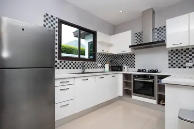 a kitchen with a stainless steel refrigerator and a window at Private Pool Villa Nai Harn Beach in Rawai Beach