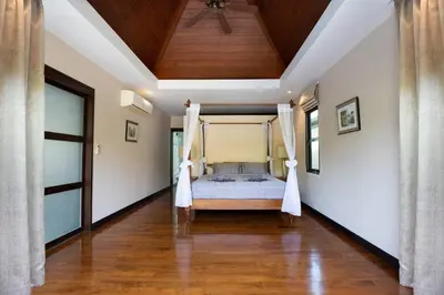 a bedroom with a bed and a wooden ceiling at Private Pool Villa Nai Harn Beach in Rawai Beach