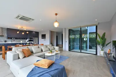 a living room with a white couch and a kitchen at 3bdr Granary Pool Villa Bangtao Beach by CapitalPro GRN-A4 in Phuket Town