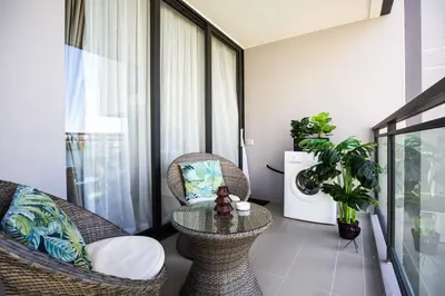 a living room with two chairs and a table at Cassia 1 BR Sea View apt by NLA in Bang Tao Beach