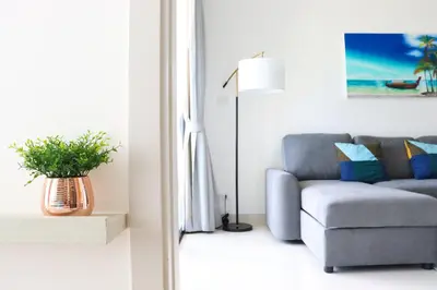 a living room with a couch and a lamp at Cassia 1 BR Sea View apt by NLA in Bang Tao Beach