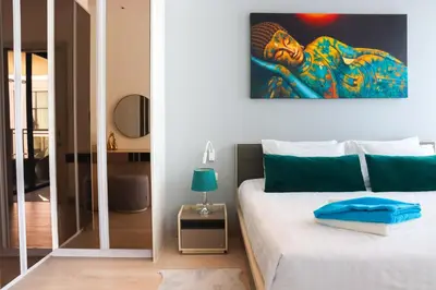 a bedroom with a bed and a painting on the wall at Cassia 1 BR Sea View apt by NLA in Bang Tao Beach