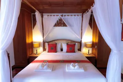 a bedroom with a white bed with red pillows at Classic Thai style Cozy Villa fancy pool+garden in Patong Beach