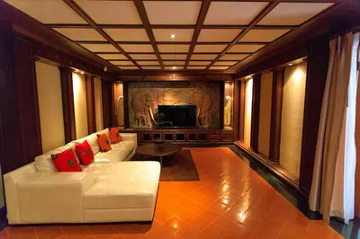 a living room with a white couch and a television at Classic Thai style Cozy Villa fancy pool+garden in Patong Beach