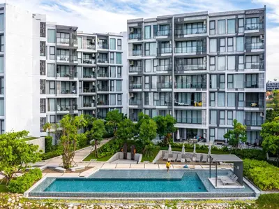 an apartment building with a pool in front of it at Cassia 1 BR Lake&Pool View apt by NLA in Bang Tao Beach