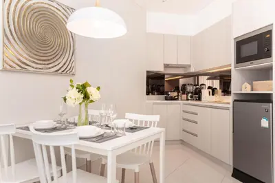 a white kitchen with a white table and chairs at Cassia 1 BR Lake&Pool View apt by NLA in Bang Tao Beach