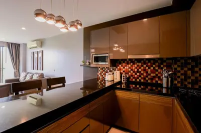 a kitchen with a counter top and a living room at The Regent Bangtao Apartments gorgeous view of the jungle in Bang Tao Beach