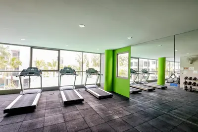a gym with a row of treadmills and green walls at The Regent Bangtao Apartments gorgeous view of the jungle in Bang Tao Beach