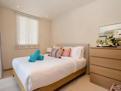 a bedroom with a large white bed with pillows at 3-Bedroom Pool Villa in Trichada Bangtao in Bang Tao Beach