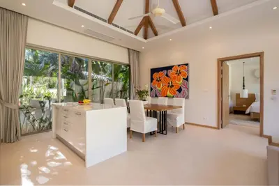 a kitchen and dining room with a table and chairs at 3-Bedroom Pool Villa in Trichada Bangtao in Bang Tao Beach