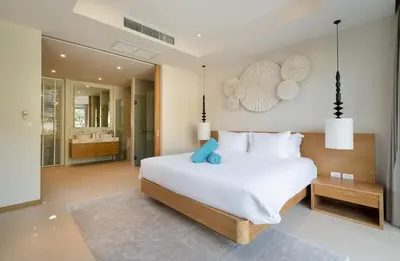 a bedroom with a large white bed and a bathroom at 3-Bedroom Pool Villa in Trichada Bangtao in Bang Tao Beach