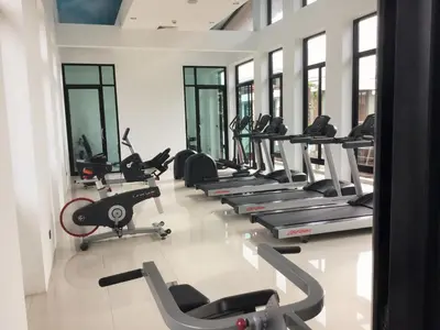 a gym with a row of treadmills and machines at Chalong Miracle Lakeview in Chalong