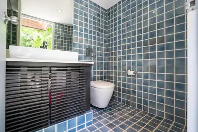 a blue tiled bathroom with a toilet and a sink at Full Seaview 5BR Villa Serenity, Elite Living at Cape Yamu in Ban Bang La