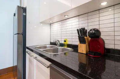 a kitchen counter with a sink and a refrigerator at Naithon beachfront apartment-pool gym restaurant in Nai Thon Beach