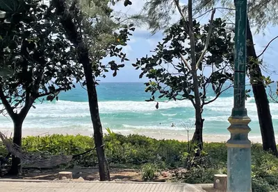a street light next to a beach with the ocean at Naithon beachfront apartment-pool gym restaurant in Nai Thon Beach