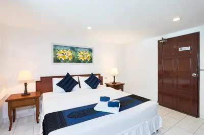 two beds in a room with two lamps and a door at Bevans Place Karon in Karon Beach