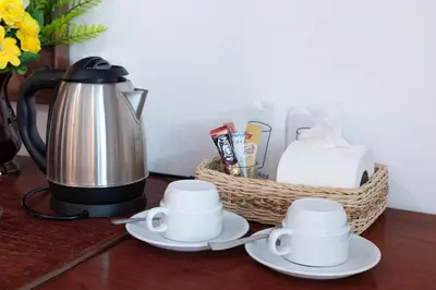 a table with two cups and a coffee pot and baskets at Bevans Place Karon in Karon Beach