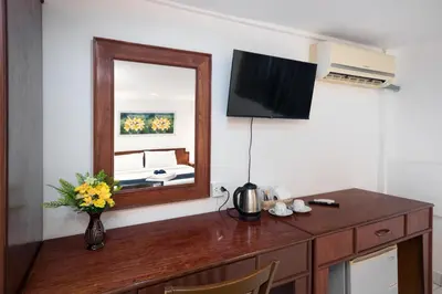 a mirror and a table with a vase of flowers at Bevans Place Karon in Karon Beach