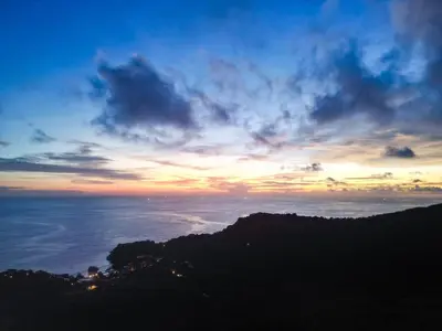 a sunset over the ocean with a mountain at Cozy 5BR Villa Stunning SeaViews in Kamala Beach
