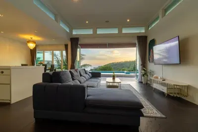 a living room with a couch and a large window at Cozy 5BR Villa Stunning SeaViews in Kamala Beach