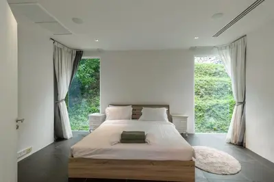 a bedroom with a bed and a large window at Cozy 5BR Villa Stunning SeaViews in Kamala Beach
