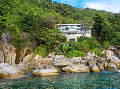 a house on a rocky hill next to the water at Villa Amanzi Kamala by Elite Havens in Kamala Beach