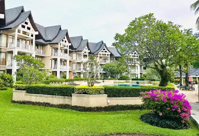 a large apartment building with a yard with flowers at Golf View, Allamanda 3 Apartment in Ban Mut Dok Khao