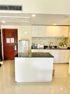 a kitchen with white cabinets and a black counter top at Golf View, Allamanda 3 Apartment in Ban Mut Dok Khao