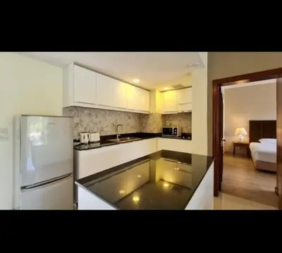 a kitchen with a sink and a refrigerator and a room at Golf View, Allamanda 3 Apartment in Ban Mut Dok Khao
