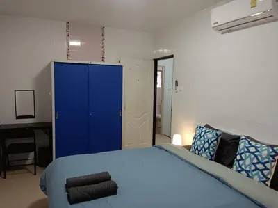 a bedroom with a blue bed and a blue cabinet at Naka Tangerine Holiday Home by Bcare in Ban Rangeng