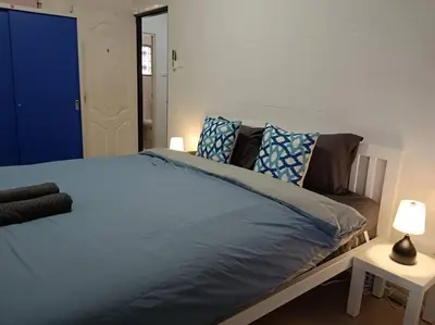 a bedroom with a bed with blue sheets and pillows at Naka Tangerine Holiday Home by Bcare in Ban Rangeng