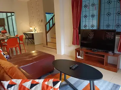 a living room with a couch and a tv and a table at Naka Tangerine Holiday Home by Bcare in Ban Rangeng