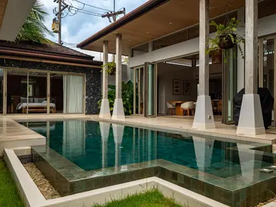 a swimming pool in front of a house at Exclusive Villa Botanica in Bang Tao Beach